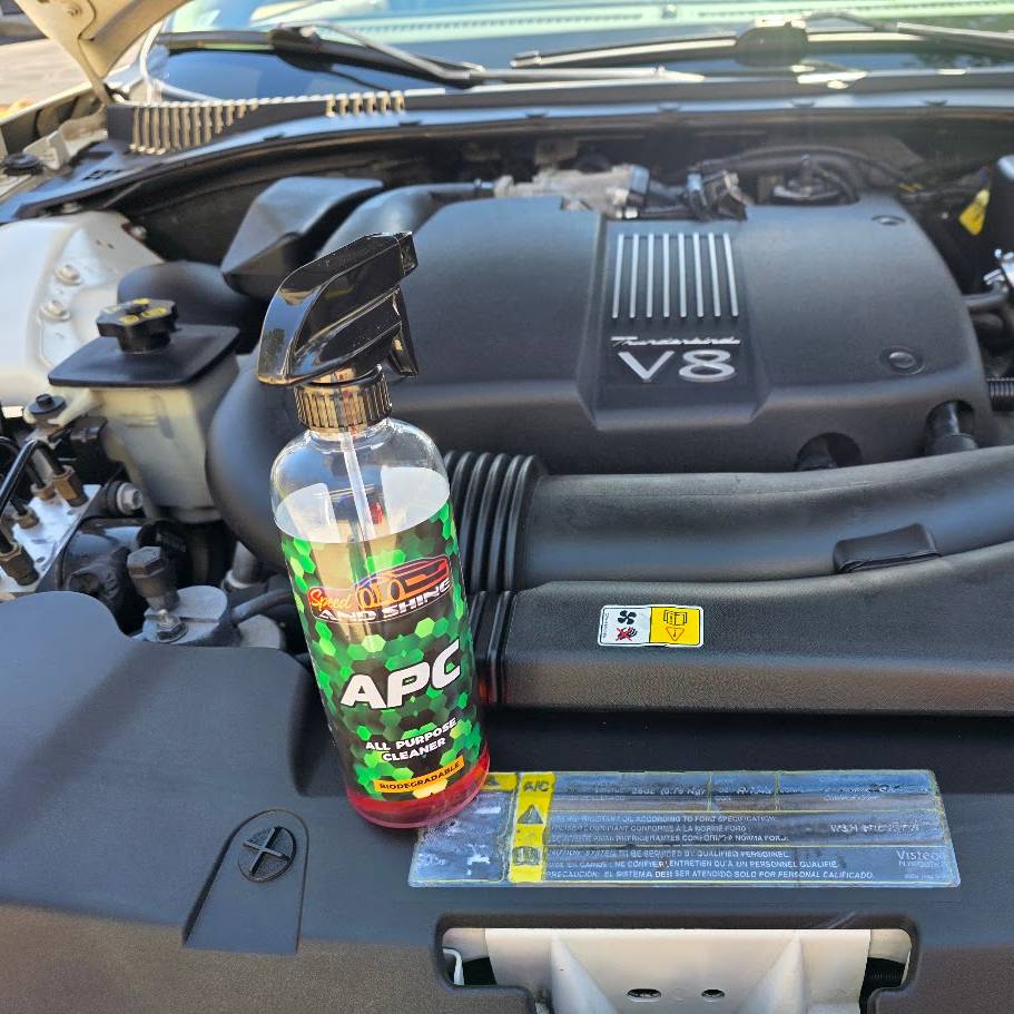 A bottle of APC spray placed on a car engine bay