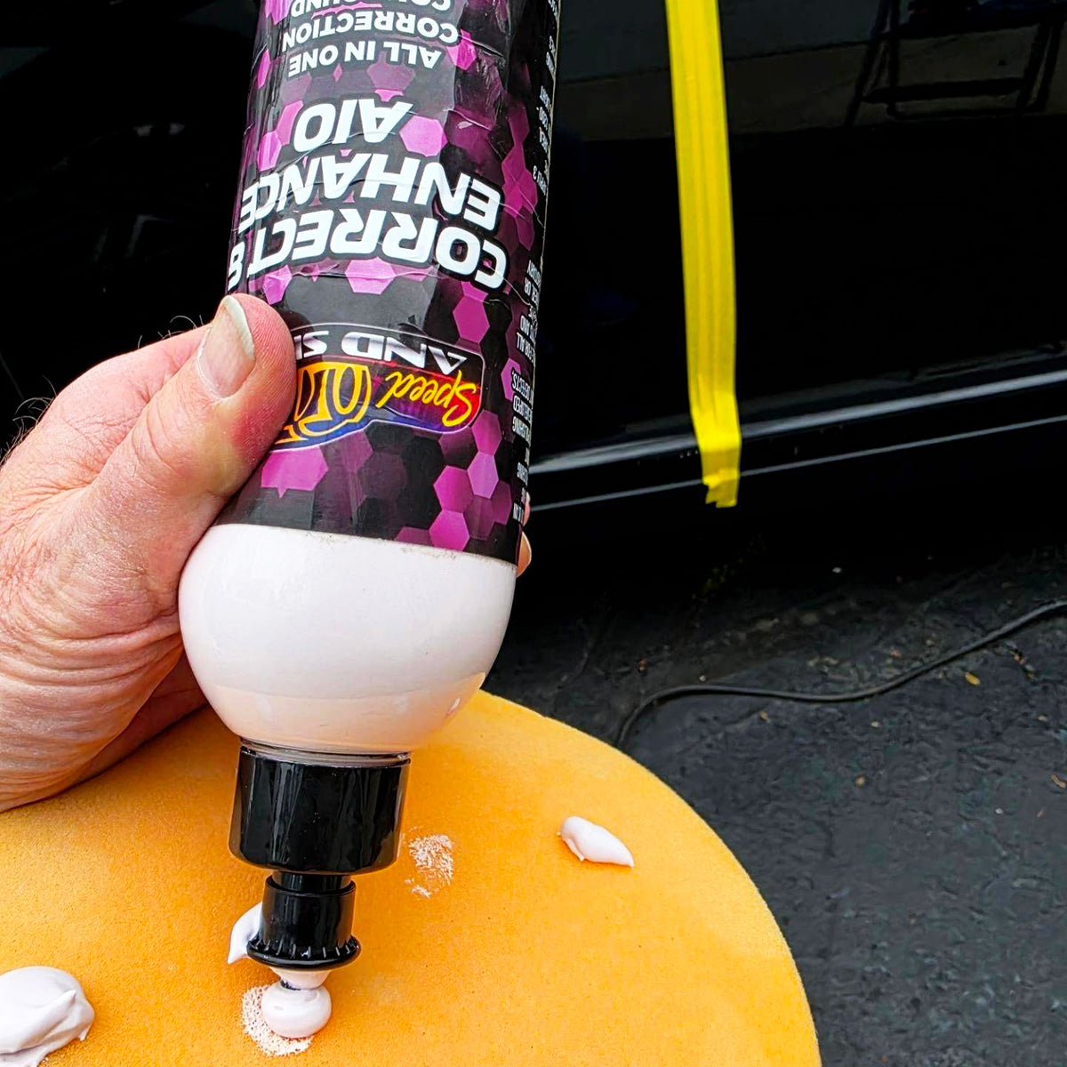 A hand holds a tube of Speed And Shine Correct & Enhance AIO 16 oz