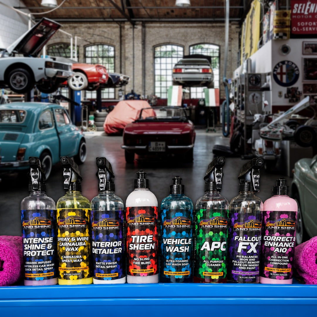 A row of 8 Speed And Shine professional car care products lined up in a garage setting.